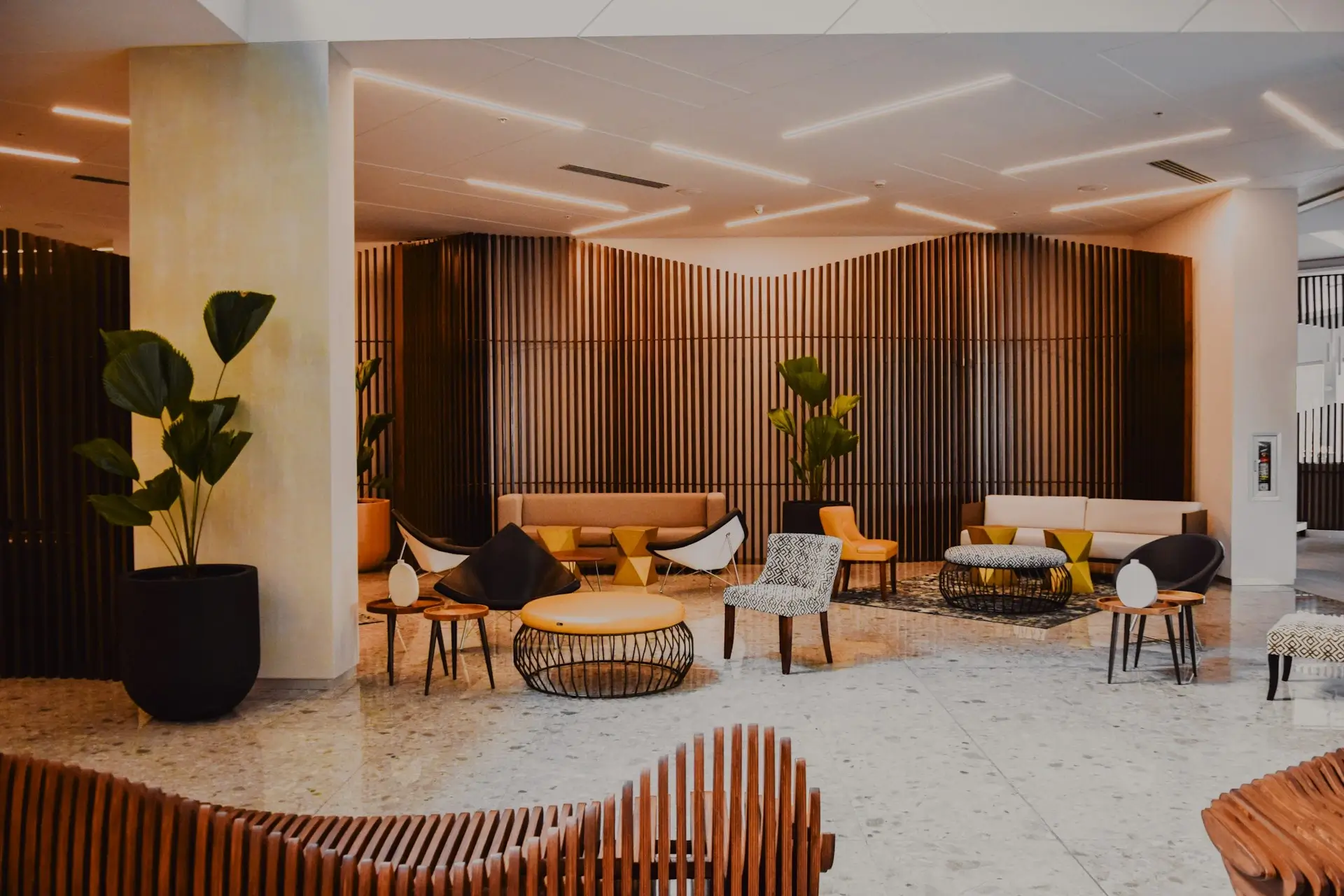 Nowoczesne lobby hotelowe z designerskimi meblami i roślinami, symbolizujące przestrzeń, w której można efektywnie zarządzać personelem branży hotelarskiej i restauracyjnej
