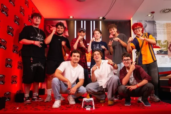 Grupa młodych mężczyzn pozuje do zdjęcia na czerwonym dywanie na tle ścian z logo "KFC Fight for the Last Bite".