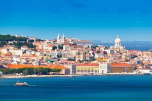 Panorama Lizbony z widokiem na kolorowe kamienice, historyczne kościoły i plac Praça do Comércio nad brzegiem rzeki Tag.